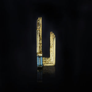 18ct gold artistic lapel pin with handmade textured layers and blue indicolite tourmaline baguette