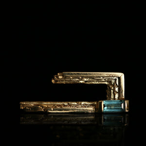 18ct sculptural gold lapel pin with handmade textured layers and blue tourmaline baguette