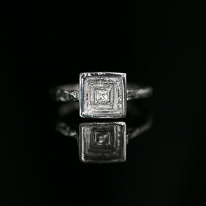 Handmade 18ct white gold engagement ring with princess cut brilliant diamond and eroded texture