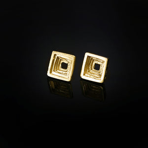 Cavetto architectural stud earrings in 18kt gold and square concave stratified profile. 