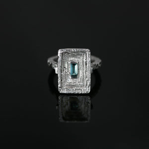 Statement Corona Cliviae 18kt white gold ring with teal blue indicolite tourmaline and architectural silhouette, front view.