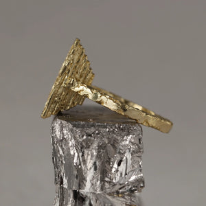 Frustum ring artfully handcrafted in sculpted 18kt gold wire and white baguette diamond, with textured stratified crown, angled view.