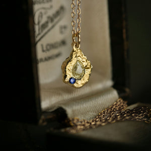 Lava Jonquil statement pendant necklace in 18kt gold with pear yellow diamond and blue sapphire, angled view.