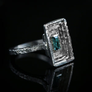 Corona Cliviae statement ring in 18kt white gold and baguette teal blue indicolite tourmaline and architectural construction.