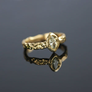 Lava Naples sculptural 18kt gold engagement ring with pale yellow marquise diamond and molten ancient texture, angled view.