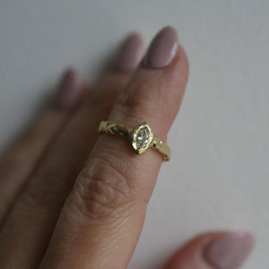 Lava Naples 18kt yellow gold engagement ring with pale yellow marquise diamond and raw sculpted texture, presented on hand.