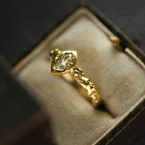 Lava Naples radiant 18kt gold engagement ring with pale yellow marquise diamond and volcanic-like molten texture, side view.